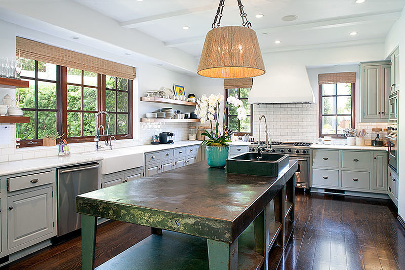 The forest-green kitchen island gives the space a pop of ...