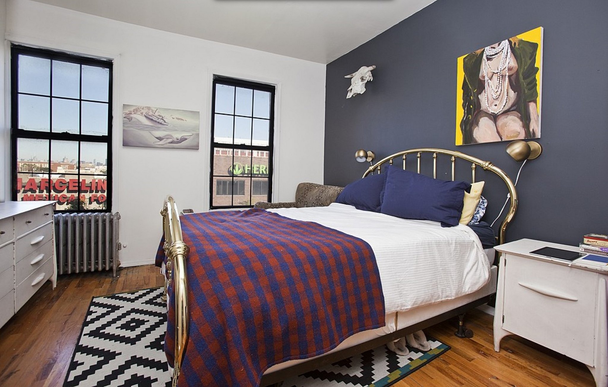 A navy-blue accent wall is the focal point of this bedroom. | Inside ...